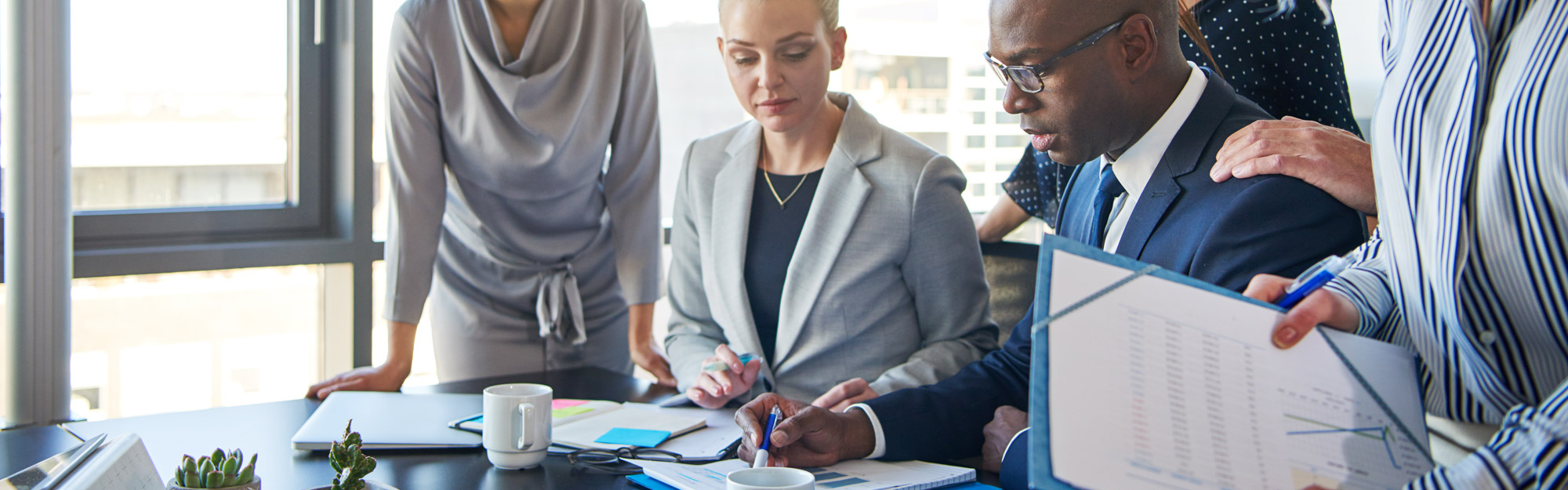 Group Of Focused Business People Standing Around Their Manager